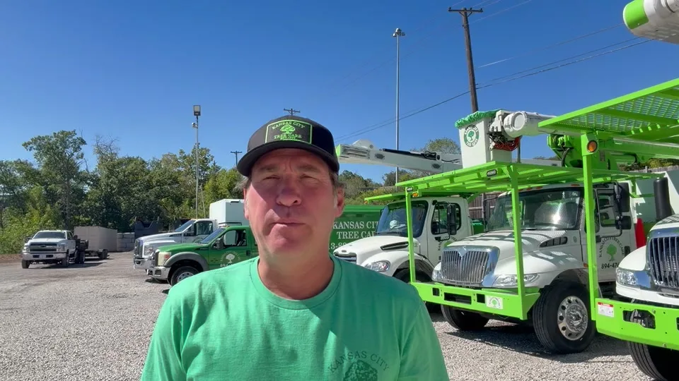 Zach Johnson, owner of Kansas City Tree Care, in front of the company bucket trucks