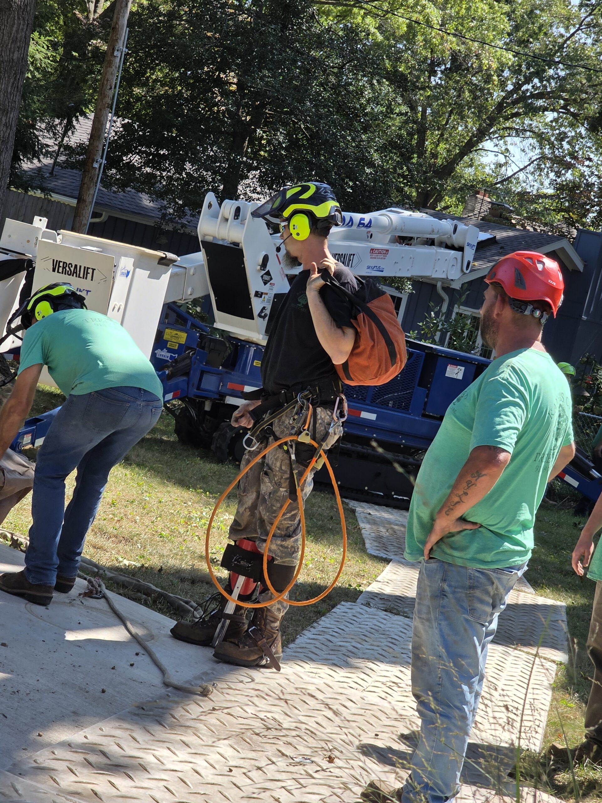 arborists using harness, ropes, and crane for safe kansas city tree removal in mature neighborhood street